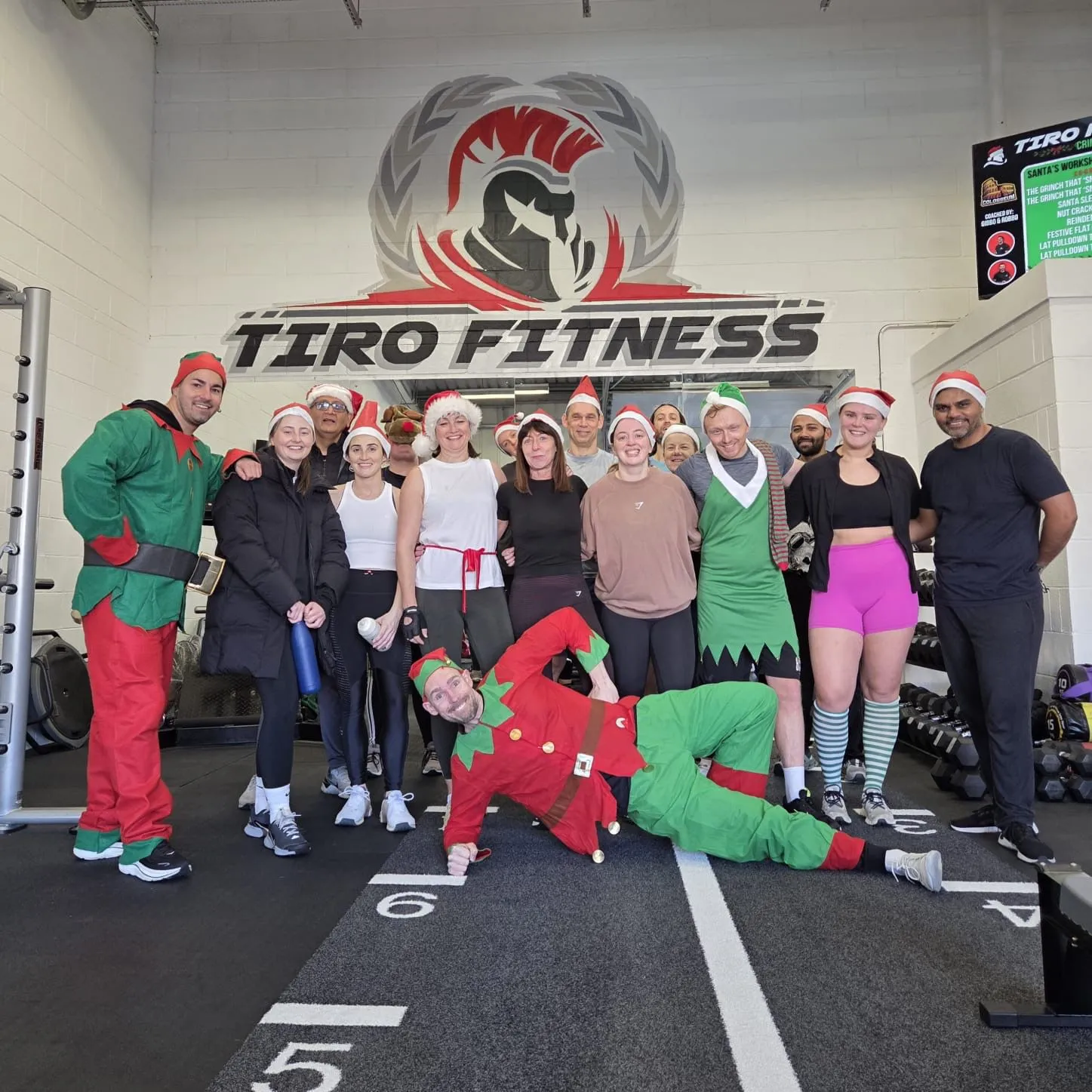 Tiro Fitness Christmas group photo with members in elf costumes and Santa hats